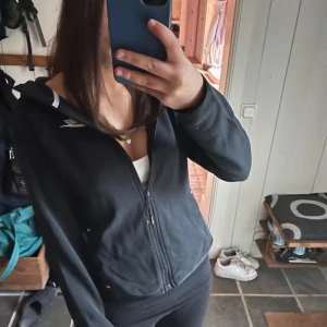 Svart hoodie från Nike - Säljer en svart hoodie från Nike i storlek XS. Den har en dragkedja framtill och en huva. Perfekt för en sportig look eller en avslappnad dag. Nike-loggan syns på bröstet. Hör av dig för fler bilder!!💓💓