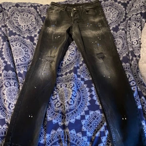Svarta jeans från Dsquared2 - Snygga svarta jeans från Dsquared2 med coola slitningar och färgstänk. Äkta jeans pris kan minska vid snabb affär 
