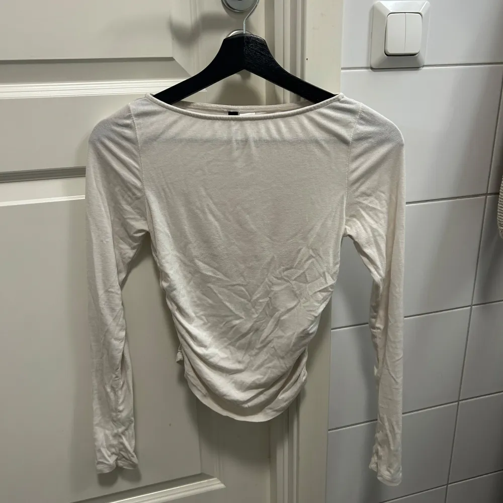 Säljer en stilren vit långärmad topp från H&M Divided. Toppen har en åtsittande passform och är tillverkad i ett mjukt material som ger en bekväm känsla. Perfekt för att matcha med jeans eller kjol. Hör av dig vid intresse!. Yläosat.