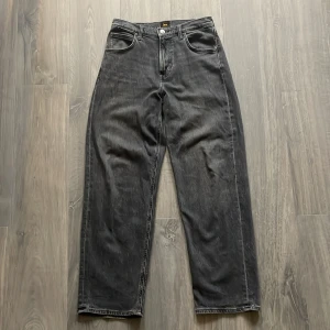 Lee jeans - Ett par mörka jeans från Lee. Modell Asher vilket är en baggy modell. Storlek W28 men de är ganska stretchiga i midjan så de kan passa större. Inga defekter✅. Tveka inte att skriva vid frågor👍