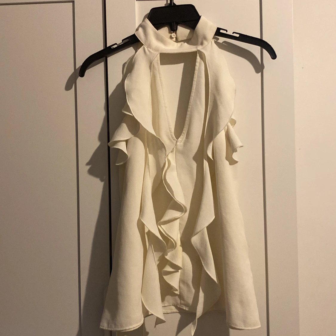 Vit ärmlös blus med volangdetaljer