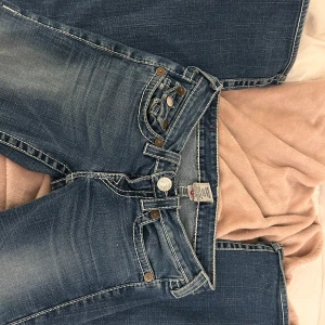 Blå jeans med broderade fickor - Skitsexiga true religion jeans i storlek s. De är raka i benen, alltså int skinny🤩 w 26, längd vet jag ej men passar mig som är 1.65