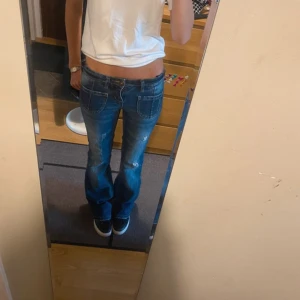 Blå bootcut jeans - Snygga blå bootcut jeans med slitna detaljer. De har en låg midja och klassiska femficksdesign. Säljer för de inte passar mig. 