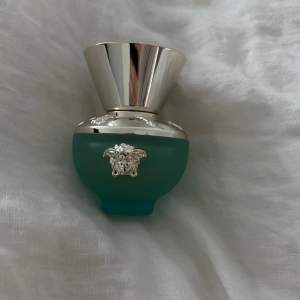 Elegant parfymflaska i frostat turkost glas med silverdetaljer från Versace. Flaskan har en lyxig design med ett silverlock och den ikoniska Medusa-loggan i silver på framsidan. Perfekt för den som älskar exklusiva dofter och stilfull design. En fräsch och blommig doft. 30ml knappt använd 