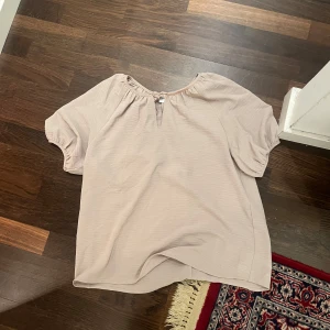 Beige blus med knytning - Skit snygg beige blus till sommaren med knytning, den ser lite konstig ut eftersom den har blivit för liten på mig den var mycket finare innan när den satt lite lösare 