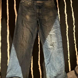Blå jeansbyxor - Hope jeans. Storlek 36. Slitningen är en del av designen