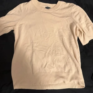 Beige tröja från Stockh LM - Säljer en stilren beige tröja från Stockh LM. Tröjan har en rund halsringning och ribbade kanter vid ärmslut och nederkant. Perfekt för en avslappnad look.