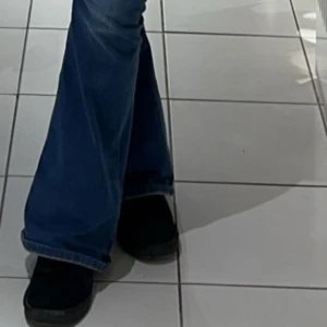 Blå bootcut jeans - Snygga blå bootcut jeans med hög midja. Perfekta för en avslappnad stil med en modern twist. De har klassiska femfickor och en bekväm passform.