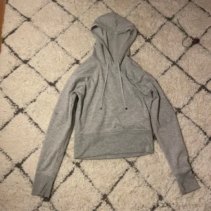 Victoria secret - Säljer en stilren grå hoodie från victoria secret med huva och dragsnören. Tröjan har långa ärmar med tumhål för extra komfort. 