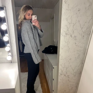 Grå stickad tröja från BikBok - Säljer en mysig grå stickad tröja från BikBok med kabelstickat mönster. Tröjan har en v-ringad design och långa ärmar, perfekt för kyligare dagar. Den är både stilren och bekväm, idealisk för höst och vinter.