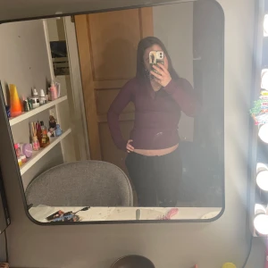 Vinröd långärmad topp med spetsdetalj - Snygg vinröd topp med v-ringning och spetsdetaljer. Perfekt för en stilren look. Långärmad och figurnära passform.