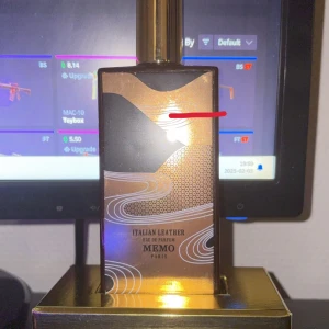Italian Leather Eau de Parfum från Memo Paris - Elegant parfymflaska med en lyxig design i guld och svart. Flaskan har ett konstnärligt mönster som ger en exklusiv känsla. Perfekt för den som söker en sofistikerad doftupplevelse. Se bild för mängd. Full pres finns. Flaskan är 75 ml. Nypris ca 2500