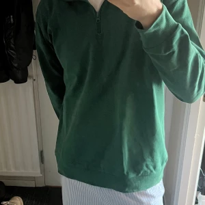Grön tröja med dragkedja - Säljer en grön tröja med dragkedja vid halsen. Storlek S men är ganska stor så passar M/L