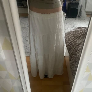 Vit långkjol - Säljer en vit långkjol med elastisk midja. Kjolen har en luftig och avslappnad passform, perfekt för varma dagar. 