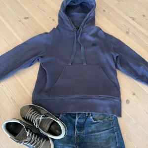 Mörkblå hoodie från Acne Studios - Säljer en snygg mörkblå hoodie från Acne Studios. Den har en klassisk design. Tröjan är i en sjukt snygg tvättad blå färg. Den är i väldigt bra skick och är i storlek M. Nypris ligger på 2600kr!! 