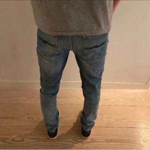 Blå jeans, nudie jeans - Snygga blå jeans med en broderad detalj på bakfickorna. De har en klassisk femficksdesign och en bekväm passform. Perfekta för en avslappnad stil.