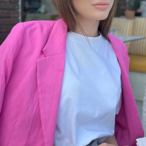 Rosa kavaj - Snygg rosa kavaj som ger en färgklick till din outfit. Perfekt för att lyfta en enkel look med sin starka färg och stilrena design. Passar bra till både vardag och speciella tillfällen.