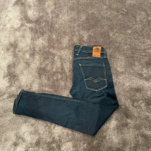 Mörkblå Replay Anbass jeans!🙌 - Snygga mörkblå jeans från Replay, modell Anbass. Skicket på byxorna är 9,5/10, nästintill nya! Storleken är W31 L32. Passformen är Slim fit! Perfekta för en stilren look med en modern passform. Hör av er vid frågor och funderingar!🙌