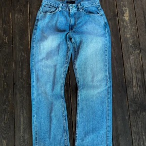 Blå Tommy Hilfiger flare Jeans - Snygga blå jeans med en straight flared passform. De är uppsydda några cm så räkna med det.