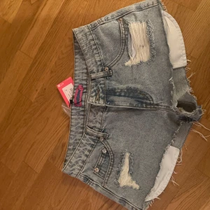 Ljusa jeansshorts med slitningar - Jättesnygga lågmidjade jeans shorts från edikted i storlek S, helt oandvända 💗