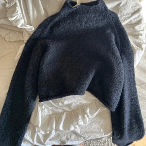 Mörkblå stickad tröja - Säljer en mysig mörkblå stickad tröja med lite högre krage. Tröjan är croppad och har långa ärmar💞 Hör av dig vid frågor eller för fler bilder💞