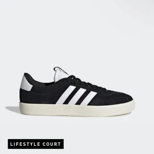 Svarta sneakers från Adidas - Snygga svarta sneakers från Adidas med de klassiska vita ränderna på sidan. Skorna har en vit sula och snörning framtill. Perfekta för en avslappnad stil.