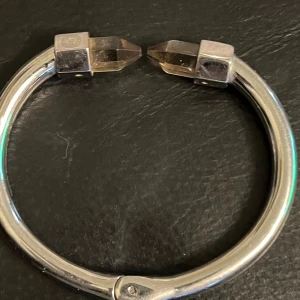 Elegant silverfärgat armband från By Malene Birger  - Elegant silverfärgat armband från By Malene Birger med unika kristalländar. Armbandet har en stilren och modern design som passar perfekt för att ge en extra touch till din outfit.