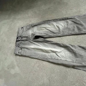 Grå jeans från Replay - (Säljs pga att den är väldigt liten för mig)Snygga grå jeans från Replay med klassisk femficksdesign och knappgylf. Perfekta för en stilren look. Märkeslapp baktill och diskreta sömmar på bakfickorna.