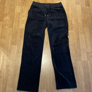 Svarta byxor från Juicy Couture. Super mjuka och sköna! - Snygga svarta byxor från Juicy Couture med  fickor knappar bak. Perfekta för en avslappnad stil med en touch av lyx. Byxorna har en loose passform och är supermjuka. Helt nya byxor! 🥰 Säjer för att köpte för stora. Älskar juicy byxor men vill gärna få dom sålda 🤩 Ni får buda och skicka till mig för mer bilder och mer info😀jag säljer dom billigt för att de bara ligger!