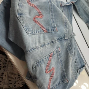 Low Waits bootcut stitch jeans  - Jag säljer dessa jätte snygga ljusblå bootcut jeans från Nelly med låg midja. De har rosa broderade detaljer på bakfickorna. Jag har lappen kvar men avdragen, så kan inte returnera dom. Bara testade, inga defekter eller skador. Säljer på grund av att de är för långa🩷 Köpta för 699kr💞 skriv för mer bilder💓