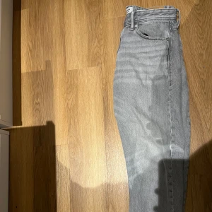 Grå jeansbyxor - Snygga grå jeansbyxor med klassisk design. De har en rak passform och är högmidjade, vilket ger en stilren look. Perfekta för en avslappnad stil.