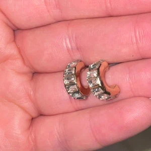 Guld- och silverfärgade örhängen med stenar - Snygga örhängen i guld- och silverfärg med rektangulära stenar. Perfekta för att ge en glittrig touch till din outfit. De har en elegant design som passar till många tillfällen.