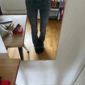 Gråa låg midjande jeans med bootcut - Snygga gråa jeans med bootcut-stil och låg midja. Perfekta för en avslappnad look. De har en klassisk femficksdesign och är tillverkade i ett slitstarkt denimtyg.