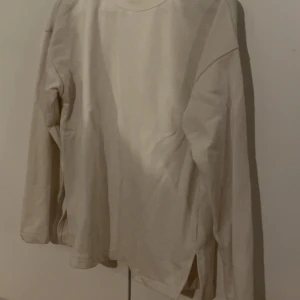 Vit långärmad tröja från H&M - Säljer en enkel och stilren vit långärmad tröja från H&M Basics. Perfekt för en avslappnad look. Tröjan har en rund halsringning och är gjord i ett mjukt material som känns skönt mot huden. Passar bra till både jeans och kjol. 🕊️