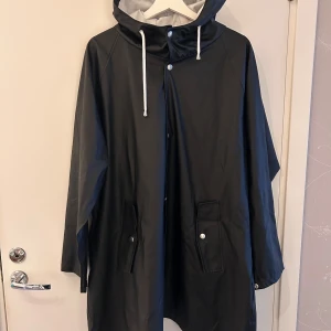 Regnjacka - Regnjacka med knapparframtill och vid ärmarna 