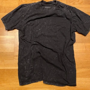 Night addict t-shirt  -  svart t-shirt från Night Addict med ett unikt 'robot wars'-tryck på baksidan. Perfekt för dig som gillar retro vibes. T-shirten har en tvättad look och korta ärmar. Perfekt skick och priset är diskuterbart