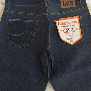 Lee Riders Jeans - Klassiska Lee Riders jeans i mörkblå denim med dragkedja och femficksdesign. Tillverkade av 100% bomull för en autentisk känsla. Perfekta för en tidlös stil.