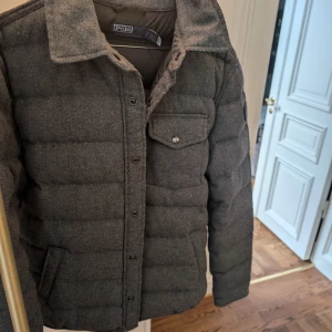 Polo Ralph Lauren quilted dun jacket stl herr S - Använd 2ggr, grå dunjacka/overshirt från Polo Ralph Lauren. Köpt i våras. Stl herr S. Nypris ca 6000 kr Mitt pris 2300 kr