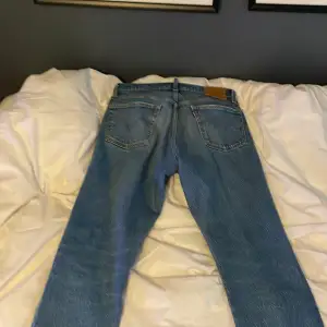 Säljer ett par klassiska blå jeans från Levi's i bra skick. De har en straight passform och är perfekta för vardagsbruk. Jeansen har en knappgylf och fem fickor. Perfekta för både höst och vår!