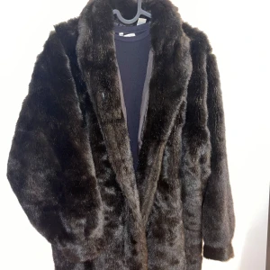 Mörkbrun pälsjacka - Säljer en supermjuk och fluffig mörkbrun pälsjacka. Perfekt för kalla vinterdagar när du vill hålla dig varm och stilren. Den är väldigt varm, jag är en S men den är overszized så man kan bära den som normal i M eller t.o.m. L. Jackan har långa ärmar och en klassisk passform som passar till alla outfits. Köpt vintage i Paris förra året