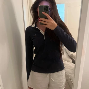 Mörkblå långärmad pikétröja - Säljer en stilren mörkblå långärmad pikétröja med vit krage. Perfekt för både vardag och lite mer uppklädda tillfällen. Tröjan har en klassisk passform och är superbekväm. Passar perfekt till jeans eller kjol!