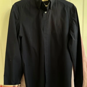 Burberry skjorta marinblå  - Säljer min marinblå burberry skjorta. Skjortan är sparsamt använd alltså i nyskick. Hojta om du vill ha fler bilder. Den är självklart äkta!  