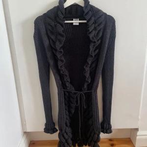 Lång kofta/cardigan - Säljer lång stickad kofta/cardigan från Veromoda som inte säljs längre i storlek M. Jag har fått den (men inte använt den) så vet inte hur mycket den är använd men är i fint skick. Färgen syns bäst på bilderna 1-3. Har detaljer (se bilder). Köparen betalar frakten! 