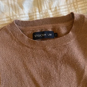 Finstickad tröja   - Ljusbrun och glittrig tröja från STOCKH LM. Storlek xs och sitter bra efter den storleken. Något nopprig! 