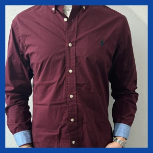 Vinröd skjorta från Ralph Lauren - Säljer en snygg vinröd skjorta från Ralph Lauren i slim fit. Skjortan är i 100% bomull. 