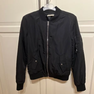 Svart bomberjacka  - Säljer en snygg svart bomberjacka i storlek S. Jackan har en dragkedja framtill och praktiska fickor med knappar. Perfekt för höst och vår! 🖤