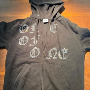 Svart hoodie från One of One - Säljer en svart hoodie från One of One, knappt använd och är i väldigt fint skick. En unik och limiterad tröja som ej går att köpa längre.