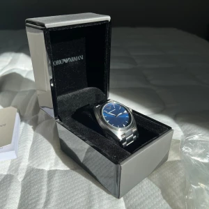 Emporio armani klocka - Emporio armani klocka Knappt använd, så inga märken på glaset. Alla länkar fås med. Batteri behöver bytas.  Det är en Armani AR11307 om man skulle vilja söka upp. Nypris: runt 3000