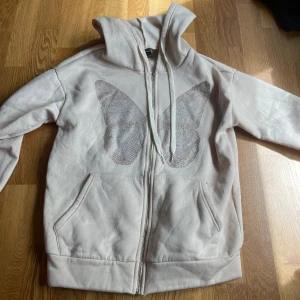 Kofta - En beige kofta med fjäril på, skön och fin men använder inte längre, ser ut som ny💕