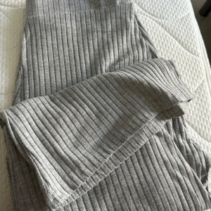 Grå ribbade byxor - Säljer ett par superbekväma grå ribbade byxor i storlek S. Perfekta för en chill dag hemma eller en avslappnad dag ute. De är mjuka och stretchiga, vilket gör dem till ett måste i garderoben. Passar perfekt till en oversized hoodie eller en enkel t-shirt.